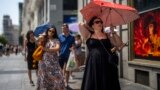 Žena sa kišobranom pokušava da se zaštiti od sunca u Madridu, 18. juli 2022. 