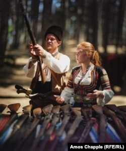 Баща със своята дъщеря около щанд с традиционни оръжия. Някои от изложените пушки са използвани в Руско-турската война от 1878 г.