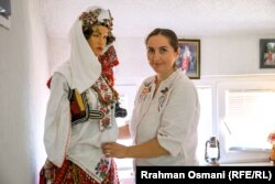 Arbnora Kolgjeraj Rexha duke e veshur një manekine me rroba tradicionale.