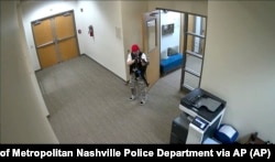 Captură de ecran a unei filmări postate pe Twitter de Departamentul de Poliție Metropolitan Nashville. Audrey Elizabeth Hale îndreaptă o armă de asalt în interiorul școlii Covenant din Nashville, Tennessee, luni, 27 martie