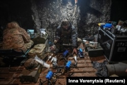 Украинский военнослужащий батальона ударных беспилотников 92-й бригады «Ахиллес» прикрепляет снаряд к FPV-дрону