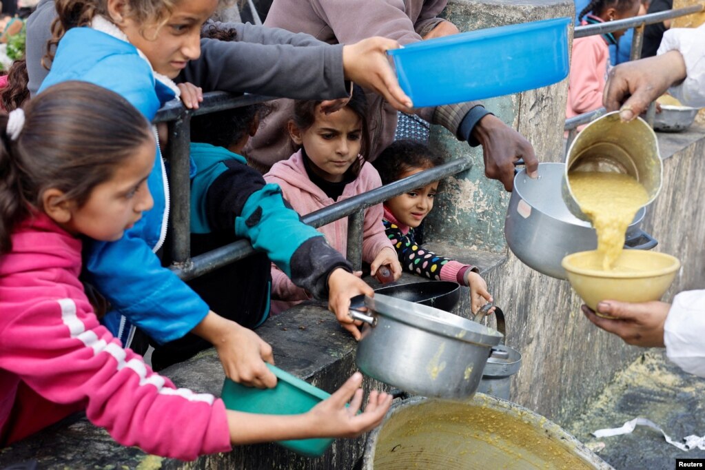 Fëmijët palestinezë duke marrë ushqim të gatuar nga një kuzhinë bamirësie.
