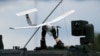 A soldier holds a drone over a NATO military vehicle during a military exercise in Lithuania in June 2023.