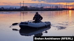 Мужчина на лодке во время паводков в Северном Казахстане