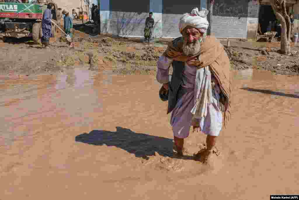 An elderly man walks through a flooded street following the flash floods after heavy rainfall.&nbsp; Afghanistan is highly vulnerable to the effects of climate change, which scientists say is making extreme weather events more harsh and more frequent.