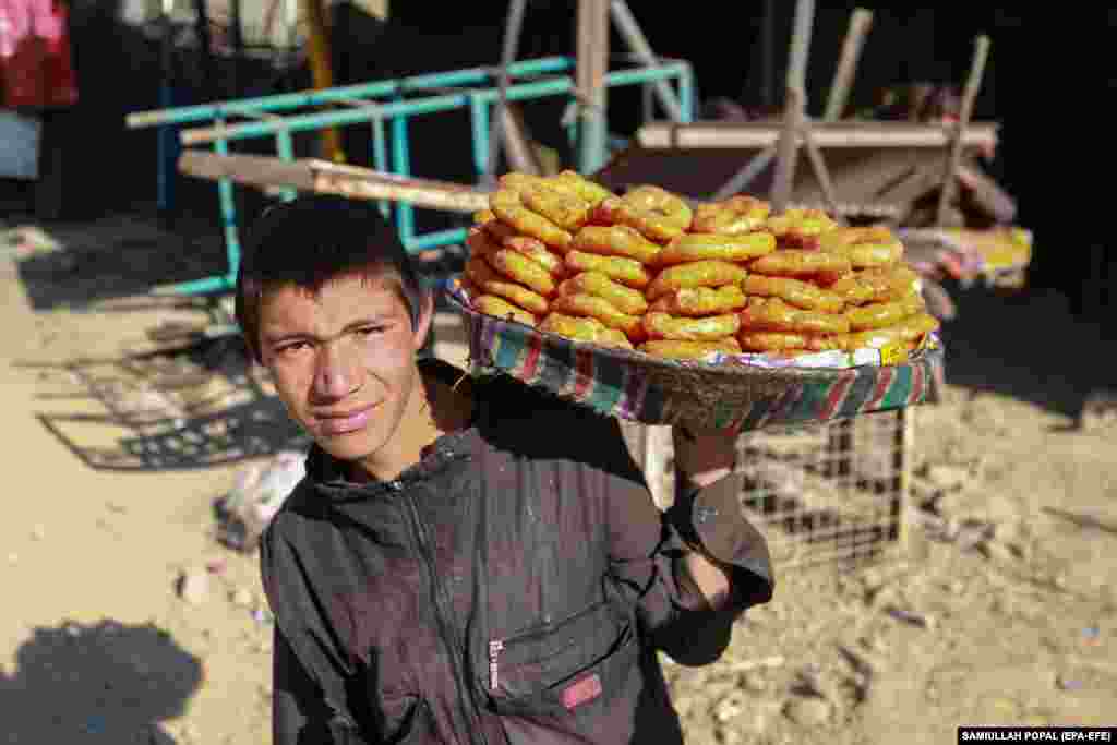 Un bărbat afgan vinde dulciuri pe marginea drumului din Kabul.