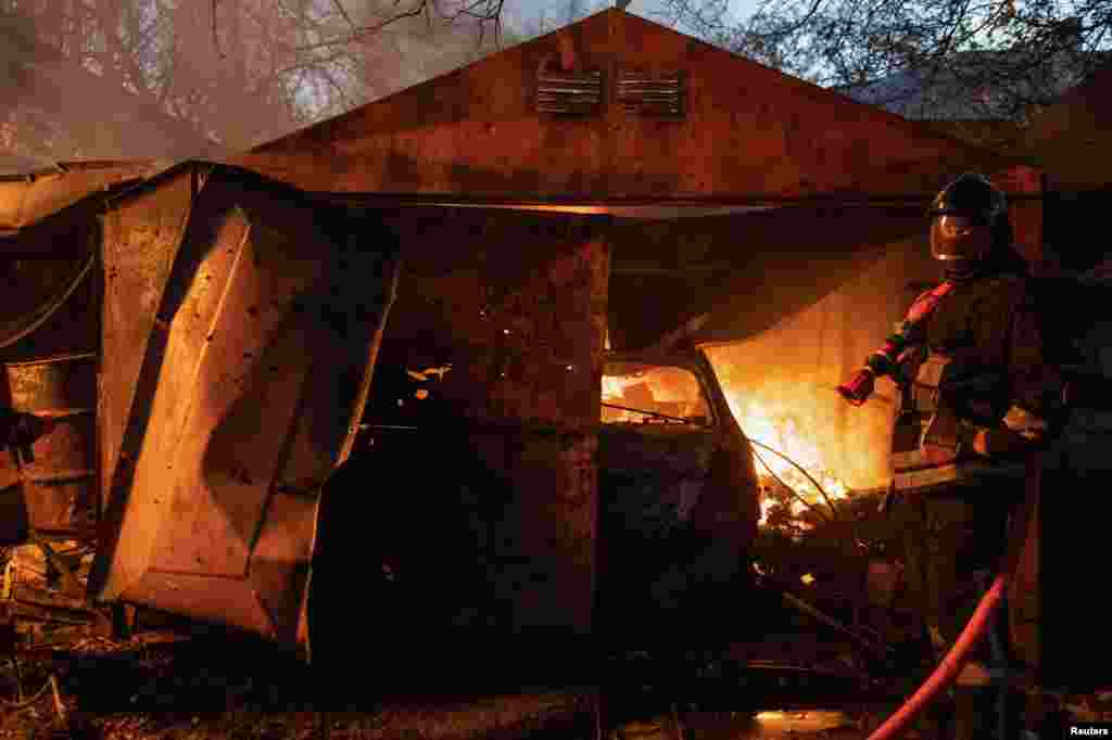 Rescue workers put out a fire in a garage.