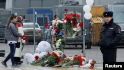 Oamenii depun flori la un memorial improvizat în memoria victimelor atacului armat la sala de concerte Crocus City Hall, din regiunea Moscovei, Rusia, 23 martie 2024. R