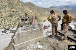 Pakistani soldiers inspect a collapsed railway a day after a blast by separatist BLA militants at Kolpur in Bolan district, Balochistan Province, on August 27.