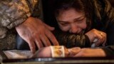 Lilia cries next to the coffin of her son, Anton Zayets, a senior lieutenant in the Ukrainian armed forces, during a funeral ceremony at St. Michael&#39;s Golden-Domed Monastery in Kyiv on March 27.