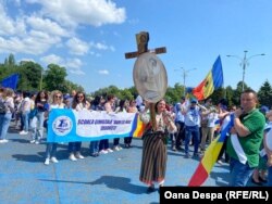 Profesoara de arte vizuale Mădălia Forțiu a venit la protest cu o cruce pe care erau versuri din Mihai Eminescu.