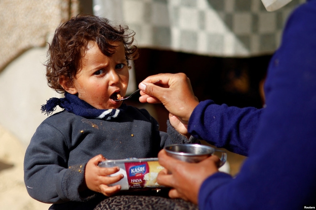 Një fëmijë palestinez i zhvendosur si pasojë e sulmeve izraelite, duke ngrënë ndërsa vazhdon konflikti midis Izraelit dhe grupit radikal palestinez, Hamas - i shpallur organizatë terroriste nga Shtetet e Bashkuara të Amerikës dhe Bashkimi Evropian. Rafah, Rripi jugor i Gazës, 20 shkurt 2024.