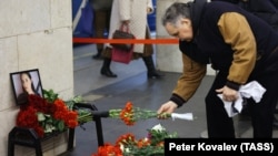 Мужчина возлагает цветы к мемориальной доске в память о жертвах теракта 3 апреля 2017 года на станции метро "Технологический институт"