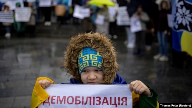 Дете държи плакат, на който пише "Демобилизация" по време на протест в Киев срещу удължаването на военната служба и намаляването на възрастта за мобилизация.