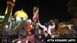 Tüntetők iráni és palesztin zászlókkal a teheráni Palesztina téren 2024. április 14-én