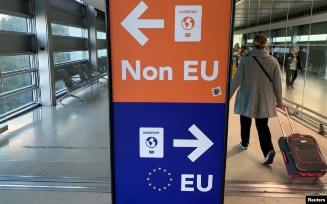Пасажири проходять повз знак, який вказує їм на певні лінії для паспортів ЄС та країн, що не входять до ЄС, під час прибуття до аеропорту Дубліна в Ірландії, 6 вересня 2019 року