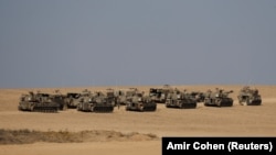 Израильские солдаты стоят рядом с артиллерийскими подразделениями возле израильской стороны границы между Израилем и сектором Газа, 3 ноября 2023 года