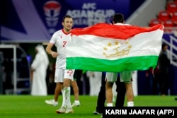A Tajikistan player celebrates with his national flag after winning the January 28 round.