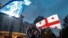 A Georgian man holds an EU flag during a celebratory rally after Georgia was granted official candidate status in Tbilisi on December 15. 