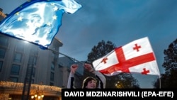 A Georgian man holds an EU flag during a celebratory rally after Georgia was granted official candidate status in Tbilisi on December 15. 