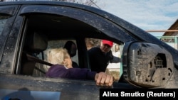 Євген Ткачов, волонтер і місцевий житель, евакуює 85-річну Нелю до притулку для внутрішньо переміщених осіб (ВПО) з її будинку в селі поблизу Часового Яру, 8 листопада 2023 року