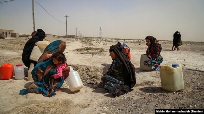 Women crouch in a former basin in Sistan and Baluchistan amid a severe water shortage on May 18.