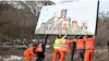 Kosovar authorities remove a billboard featuring pictures of Serbian President Aleksandar Vucic and Russian President Vladimir Putin, among others, in Zvecan, north Kosovo, on January 25.