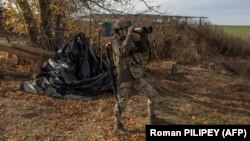 Ukrajinski vojnik nadgleda obližnje područje dvogledom, nedaleko od Hersona, Ukrajina, 2. novembar 2023.