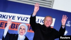 Președintele Turciei, Recep Tayyip Erdoğan, alături de soția sa, Emine, își salută suporterii la sediul Partidului Justiţiei şi Dezvoltării (AK), în noaptea de duminică spre luni, după alegerile prezidențiale pentru care ar urma să fie organizat un nou tur.