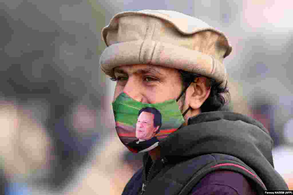 A supporter of jailed former Prime Minister Imran Khan wears a face mask displaying his picture in Rawalpindi ahead of Pakistan&#39;s upcoming general elections.