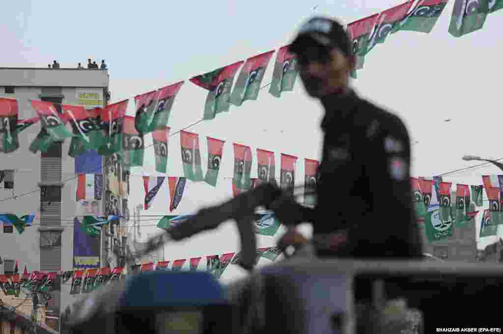 An armed Pakistani policeman stands guard during an election campaign event in the southern seaport city of Karachi.