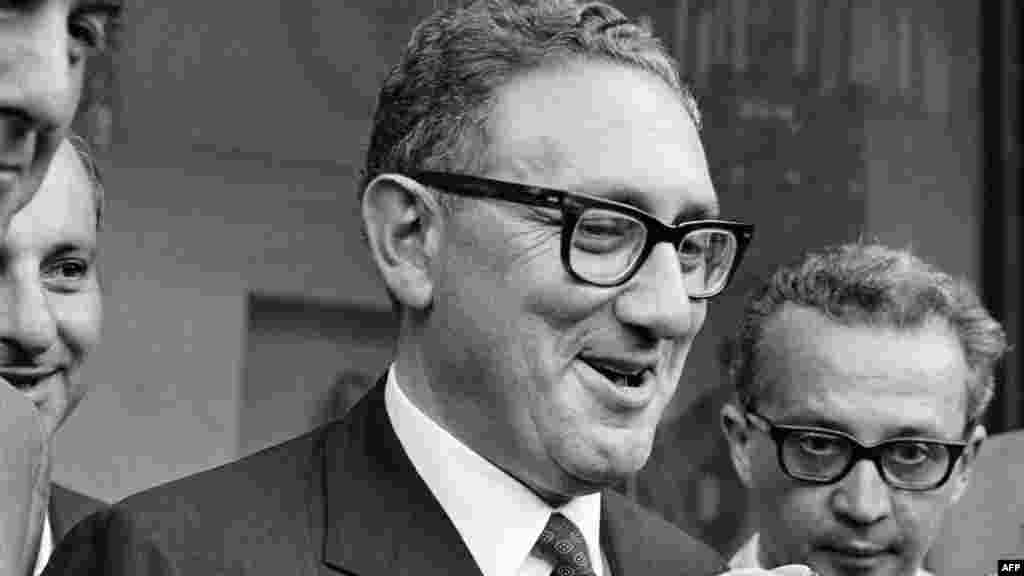 Henry Kissinger, Nixon elnök biztonsági ügyekben illetékes különleges tanácsadója újságírókhoz fordul Maurice Schumann-nal készített interjúja után Párizsban 1969. augusztus 4-én.&nbsp;A zsidó származása miatt 1938-ban New Yorkba menekülő Kissinger erőfeszítései vezettek az USA diplomáciai nyitásához Kínával, mérföldkőnek számító amerikai&ndash;szovjet fegyverzet-ellenőrzési tárgyalásokhoz, az Izrael és arab szomszédai közötti kibővített kapcsolatokhoz, valamint az Észak-Vietnámmal kötött párizsi békeszerződéshez