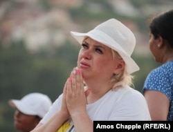 Egy nő sír a Mária-szobor előtt a Jelenések hegyén augusztus 3-án