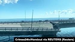 Пошкоджена ділянка дороги на Кримському мості, яка відірвалася і похилилася на бік внаслідок, як повідомляють, нічної атаки на міст. Скріншот з відео, 17 липня 2023 року
