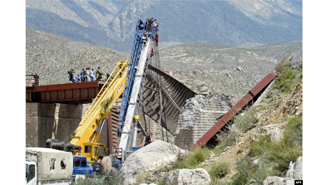 Railway officials inspect the remains of a collapsed railway bridge the morning after a blast by separatist militants at Kolpur in Bolan district, Balochistan Province, on August 27.