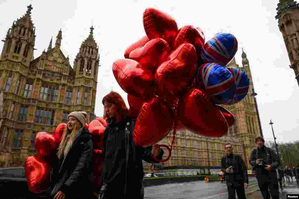 Djevojke koje nose balone u obliku srca šetaju u blizini Parlamenta na Dan zaljubljenih u Londonu, Velika Britanija, 14. februara 2024.&nbsp;