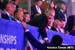 Președintele rus Vladimir Putin (centru), alături de premierul ungar Viktor Orbán și Marius Vizer, președintele Federației Internaționale de Judo, la Campionatele Mondiale de judo din 2017 de la Budapesta, Ungaria, pe 28 august 2017.