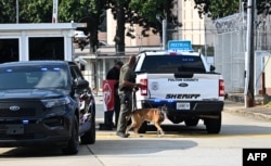 Policajac šeta sa psom ispred zatvora okruga Fulton u Atlanti, Georgia, 24. avgusta 2023.