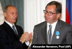 Президент России Владимир Путин (слева) аплодирует главе «Альфа-банка» Петру Авену после награждения его орденом «За заслуги перед Отечеством» во время церемонии в Кремле в Москве, 25 июля 2005 года