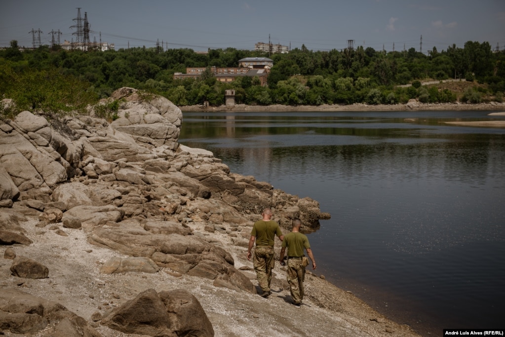 Військові йдуть біля річки Дніпро, де рівень води впав приблизно на 4 метри