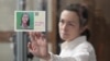 Журналистката Алсу Курмашева на изслушване в съда в Казан на 1 април 2024 г. До стъклото тя държи картичка с надпис „Очакват я у дома“.