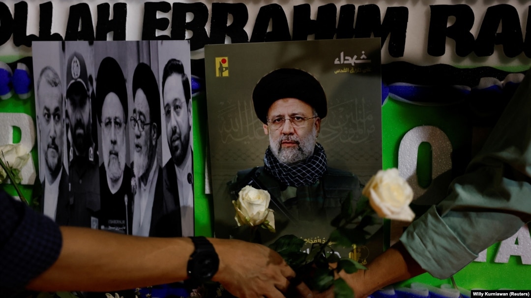 د مې پر ۲۰مه په جکارته کې د ايران د سفارت مخې ته خلګ د رييسي د عکس مخې ته ګلونه ږدي.