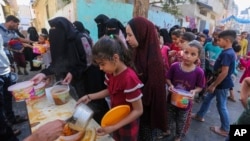 باشنده های نوار غزه برای دریافت غذا از یک نهاد خیریه٬ صف بسته اند 