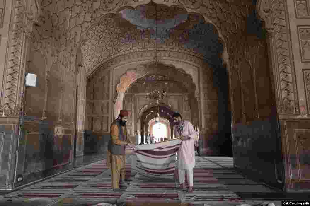 Punëtorët duke pastruar tapetet në xhaminë Badshahi në përgatitje për nisjen e Ramazanit. Lahore, Pakistan 9 mars 2024.&nbsp;