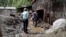 People cleaning up, removing mud from buildings after floods, Crna na Koroskem, Slovenia, August 2023.
