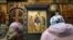 Women pray in front of Andrei Rublev's 15th-century icon Trinity 
