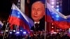 Președintele rus Vladimir Putin apare pe un ecran de pe scenă, în timp ce participă la un miting care marchează cea de-a 10-a aniversare de la ocuparea Crimeei ucrainene de către Rusia, Piața Roșie din centrul Moscovei, pe 18 martie.
