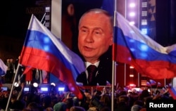 Выступление Владимира Путина транслируется на экране в Москве. Россия, 18 марта 2024 года