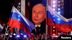 Ruski predsjednik Vladimir Putin prikazan na video-bimu dok se obraća na skupu povodom 10. godišnjice ruske okupacije ukrajinskog Krima, na moskovskom Crvenom trgu, 18. marta 2024.