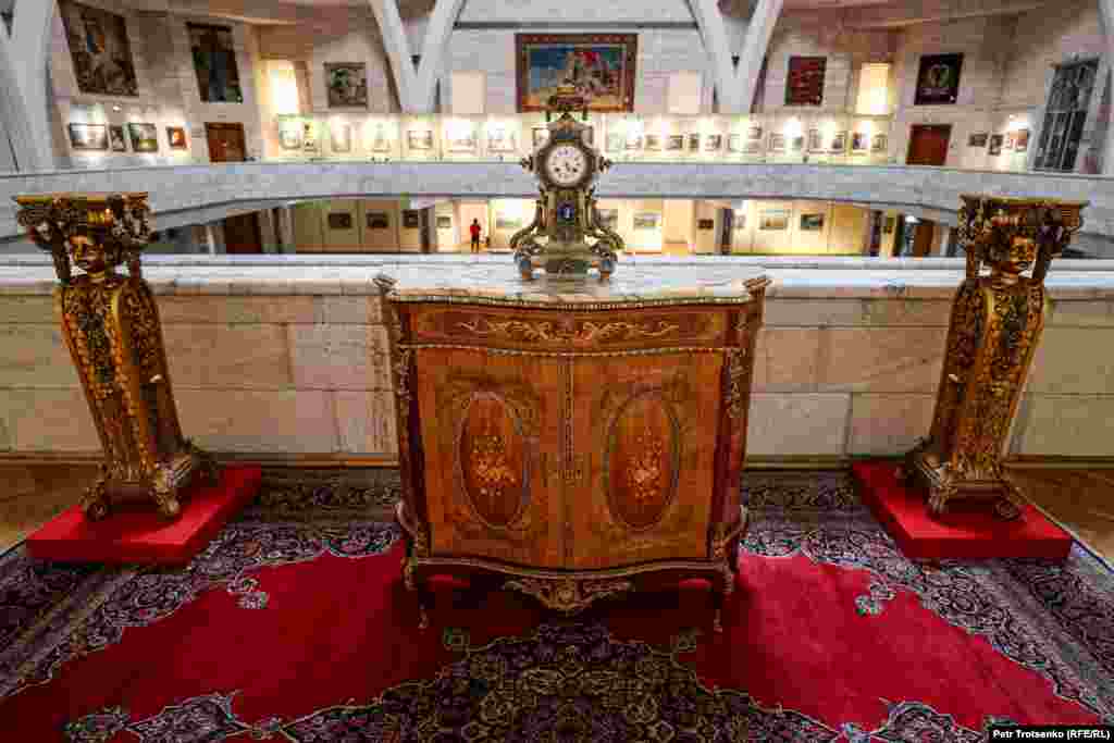 Sitting atop a wooden chest made in France at the end of the 20th century is a 19th-century clock made of bronze and onyx.